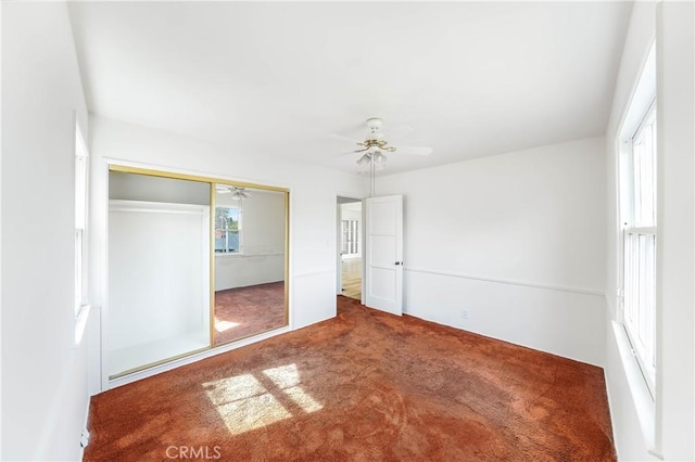 unfurnished bedroom featuring a closet, ceiling fan, and carpet floors