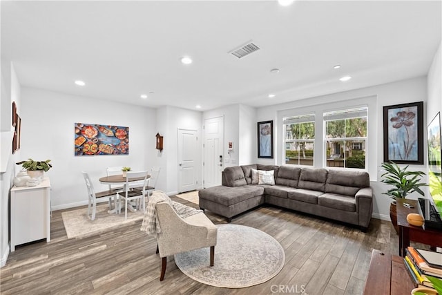 living room featuring baseboards, wood finished floors, visible vents, and recessed lighting