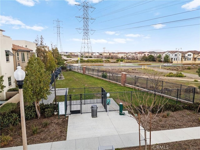 view of community with a gate, fence, and a yard