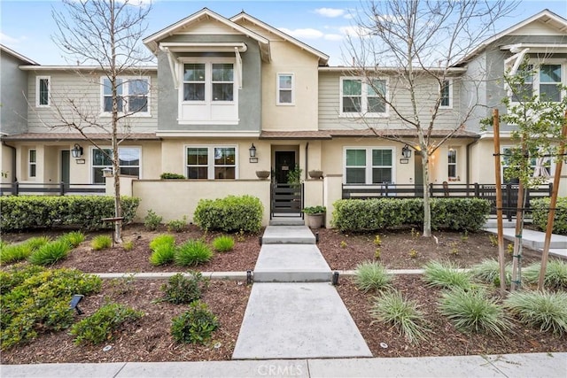 multi unit property with a fenced front yard and stucco siding