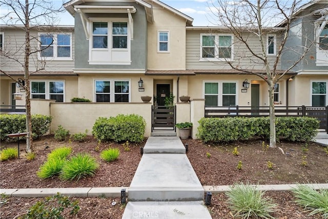 multi unit property with a fenced front yard and stucco siding