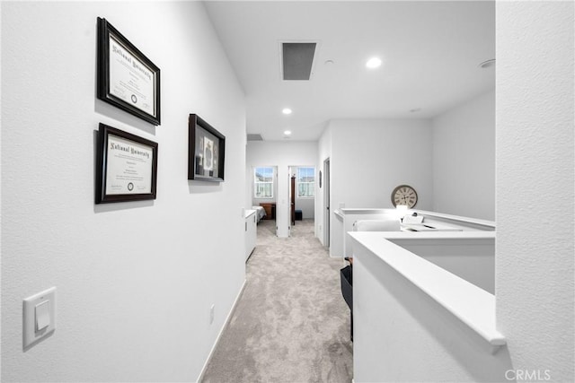 hall with light carpet, baseboards, and recessed lighting