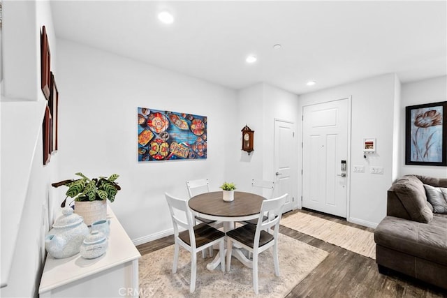 dining space featuring baseboards, wood finished floors, and recessed lighting