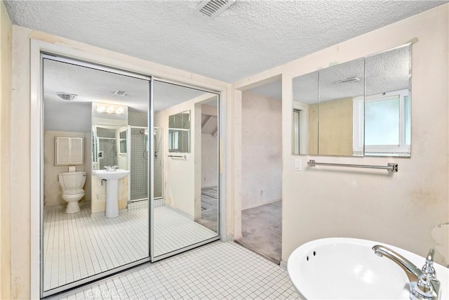 full bathroom with a sink, visible vents, and a textured ceiling