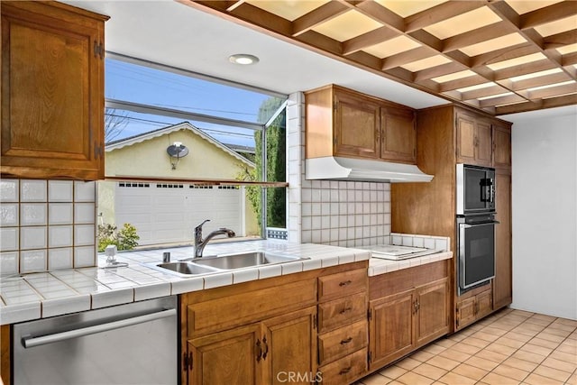 kitchen with a sink, under cabinet range hood, coffered ceiling, decorative backsplash, and dishwasher