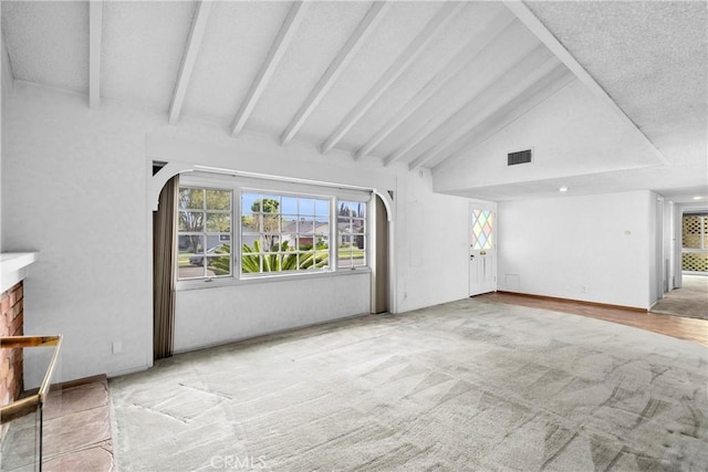 unfurnished living room with visible vents, baseboards, lofted ceiling with beams, carpet floors, and arched walkways