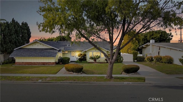 ranch-style house featuring a yard and driveway