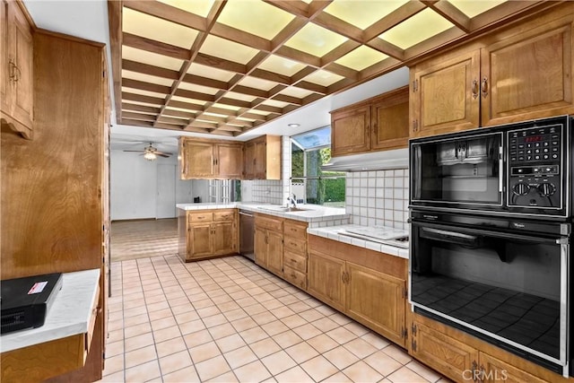 kitchen featuring backsplash, coffered ceiling, stainless steel dishwasher, tile countertops, and black microwave