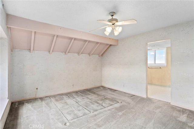 unfurnished room with lofted ceiling with beams, light colored carpet, ceiling fan, and a textured ceiling