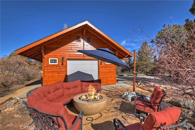 view of patio featuring an outdoor fire pit and an outbuilding