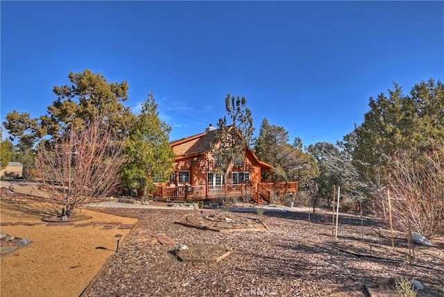 rear view of property featuring a deck