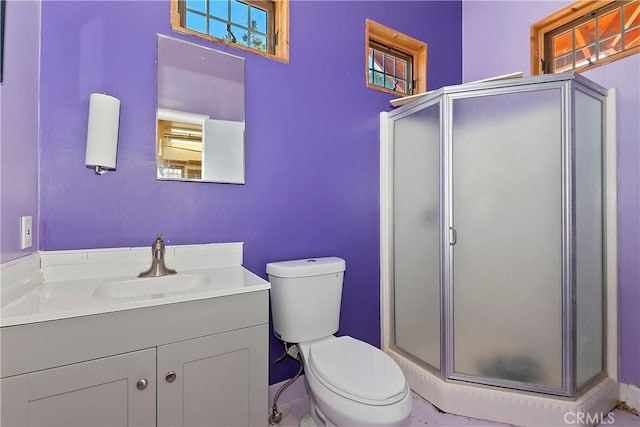 bathroom with a stall shower, vanity, and toilet