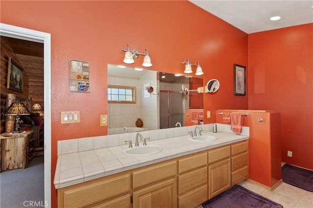 bathroom with double vanity, tile patterned flooring, a shower stall, and a sink