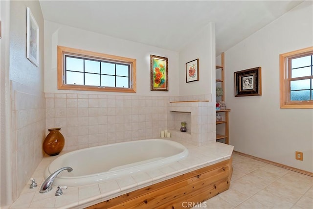 full bathroom featuring a garden tub, baseboards, and tile patterned floors