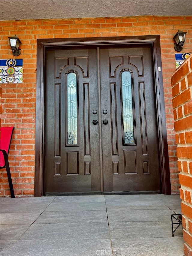 view of exterior entry featuring brick siding