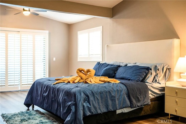 bedroom with access to exterior, lofted ceiling, ceiling fan, and wood finished floors