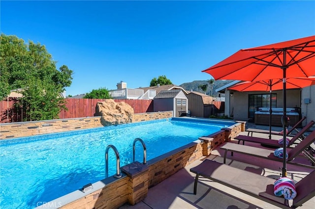 view of swimming pool featuring a fenced in pool, a patio, a storage unit, a fenced backyard, and an outdoor structure