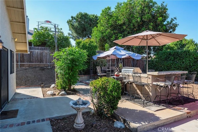 view of patio featuring fence and outdoor dry bar