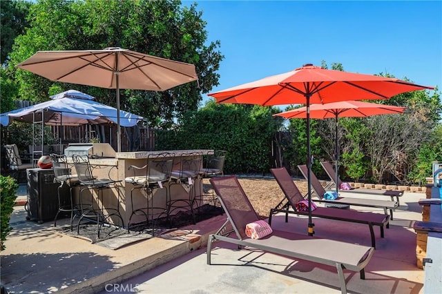 view of patio / terrace featuring outdoor dry bar and fence
