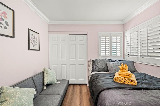 bedroom featuring ornamental molding and wood finished floors