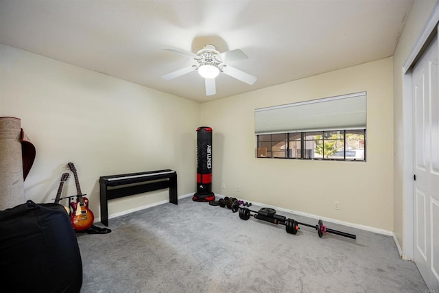 exercise room with a ceiling fan, carpet, and baseboards