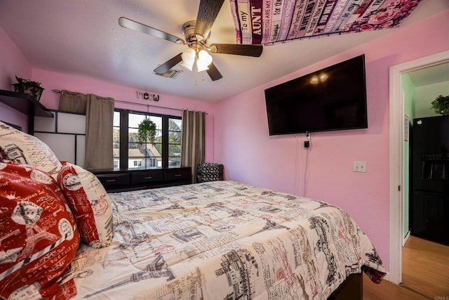 bedroom with ceiling fan, wood finished floors, and visible vents