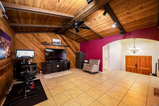 living room with arched walkways, vaulted ceiling with beams, wooden ceiling, wooden walls, and ceiling fan with notable chandelier