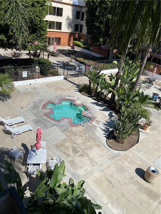 view of swimming pool with a patio, fence, and a jacuzzi