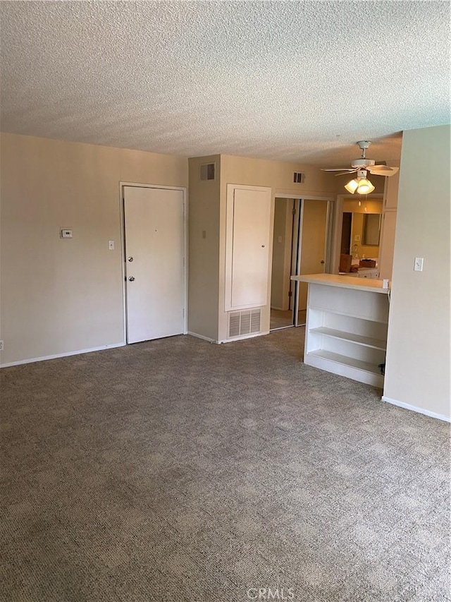 unfurnished living room featuring carpet, visible vents, and a ceiling fan