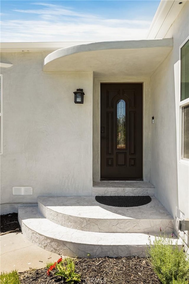 doorway to property with stucco siding