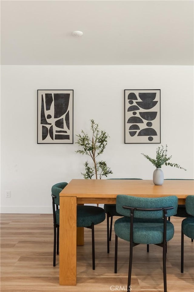 dining room featuring light wood-style floors and baseboards