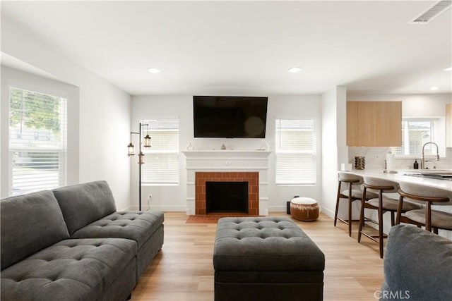 living area featuring recessed lighting, light wood-style flooring, and baseboards