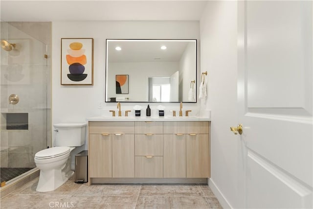 bathroom featuring a sink, a stall shower, toilet, and double vanity