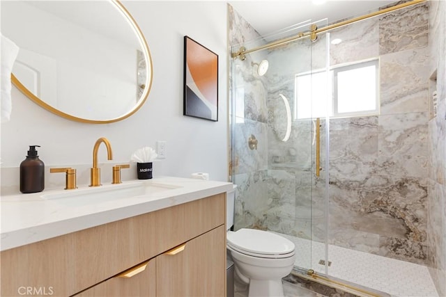 bathroom with vanity, toilet, and a marble finish shower