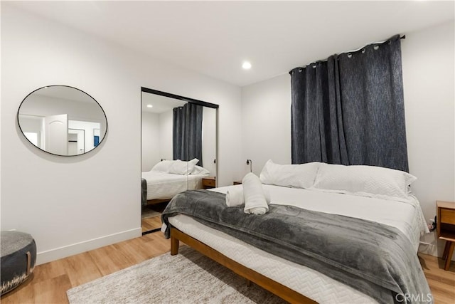 bedroom with recessed lighting, baseboards, and light wood finished floors