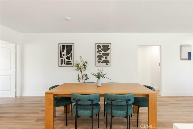 dining room featuring light wood-style floors and baseboards