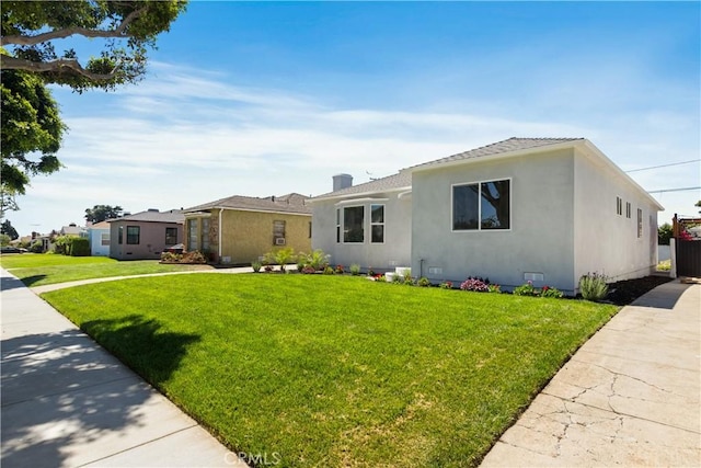 view of front of property with stucco siding and a front lawn