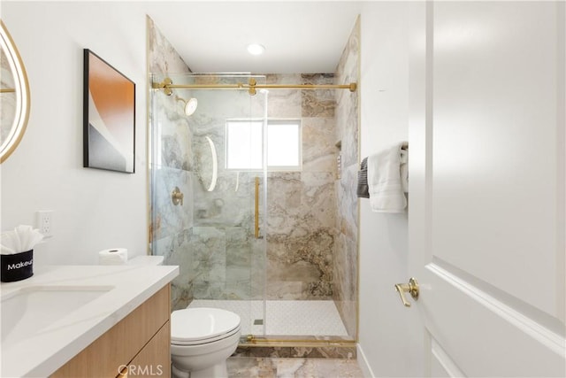 bathroom with a stall shower, toilet, and vanity