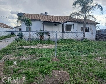 view of side of home featuring a fenced front yard and stucco siding