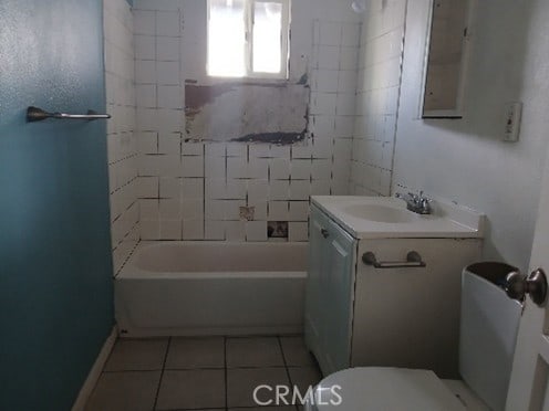 bathroom with toilet, tile patterned flooring,  shower combination, and vanity