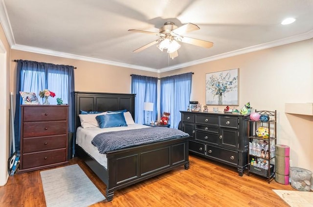 bedroom featuring crown molding, a ceiling fan, and light wood-style floors