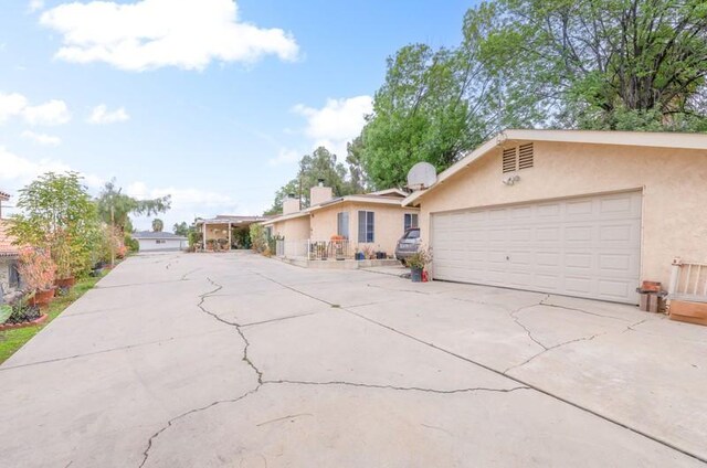 single story home featuring concrete driveway and stucco siding