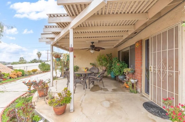 view of patio with ceiling fan, fence, and outdoor dining space