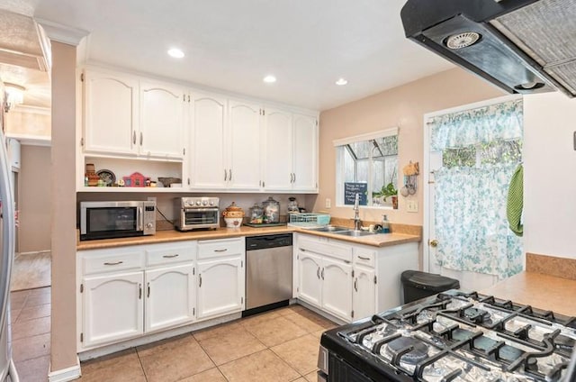 kitchen with stainless steel appliances, light countertops, white cabinetry, and a sink