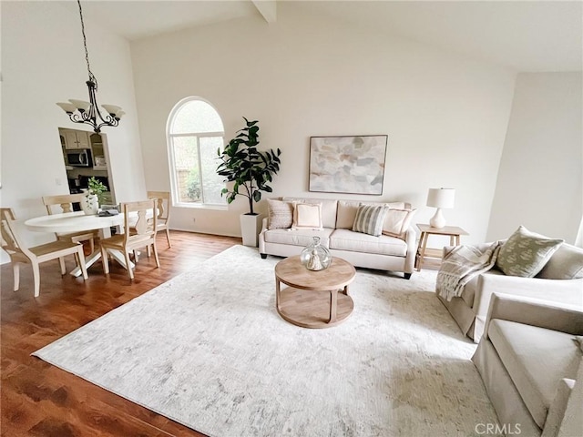 living room featuring a chandelier, beamed ceiling, high vaulted ceiling, and wood finished floors