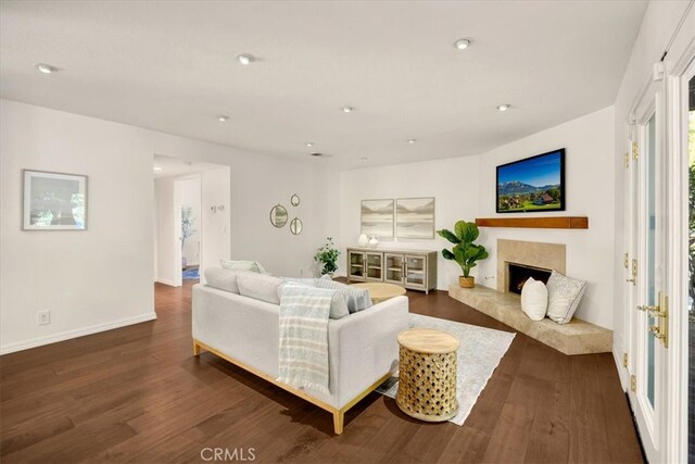 living area with recessed lighting, baseboards, dark wood finished floors, and a fireplace