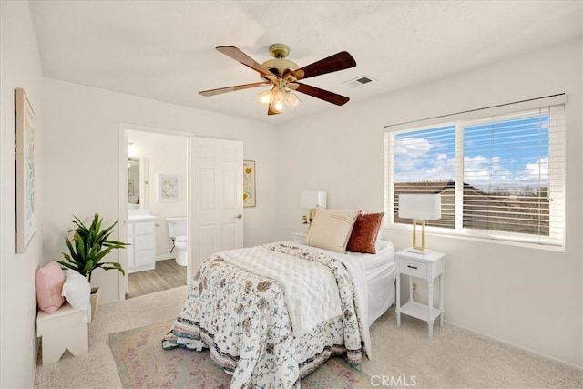 bedroom with visible vents, baseboards, ensuite bath, and a ceiling fan