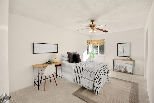 carpeted bedroom featuring a textured ceiling and a ceiling fan