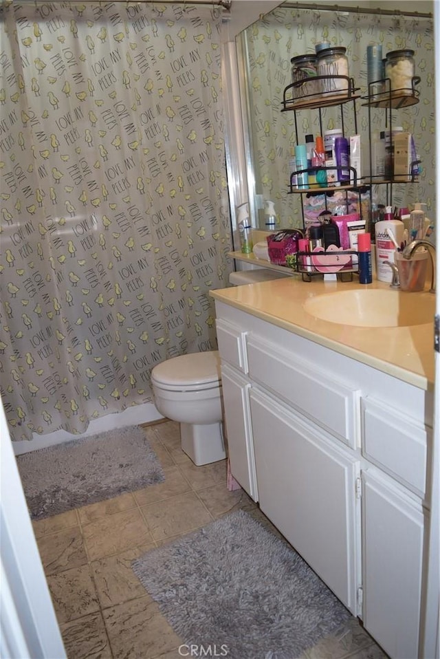 bathroom featuring a shower with shower curtain, vanity, toilet, and wallpapered walls