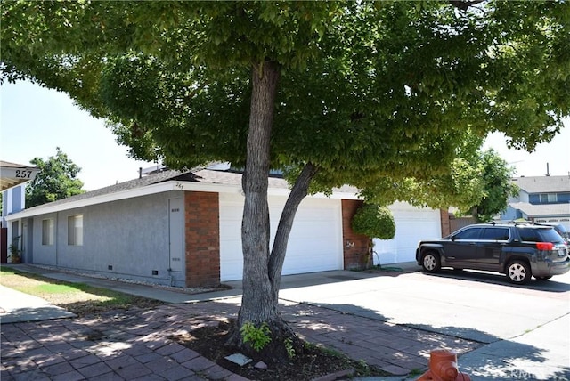 view of property exterior featuring concrete driveway and stucco siding